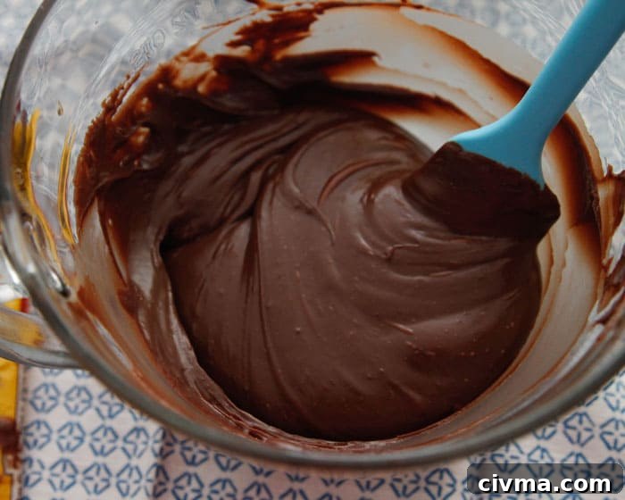 3 minute fudge A blue spatula finishes stirring the ingredients for three minute fudge in a glass bowl