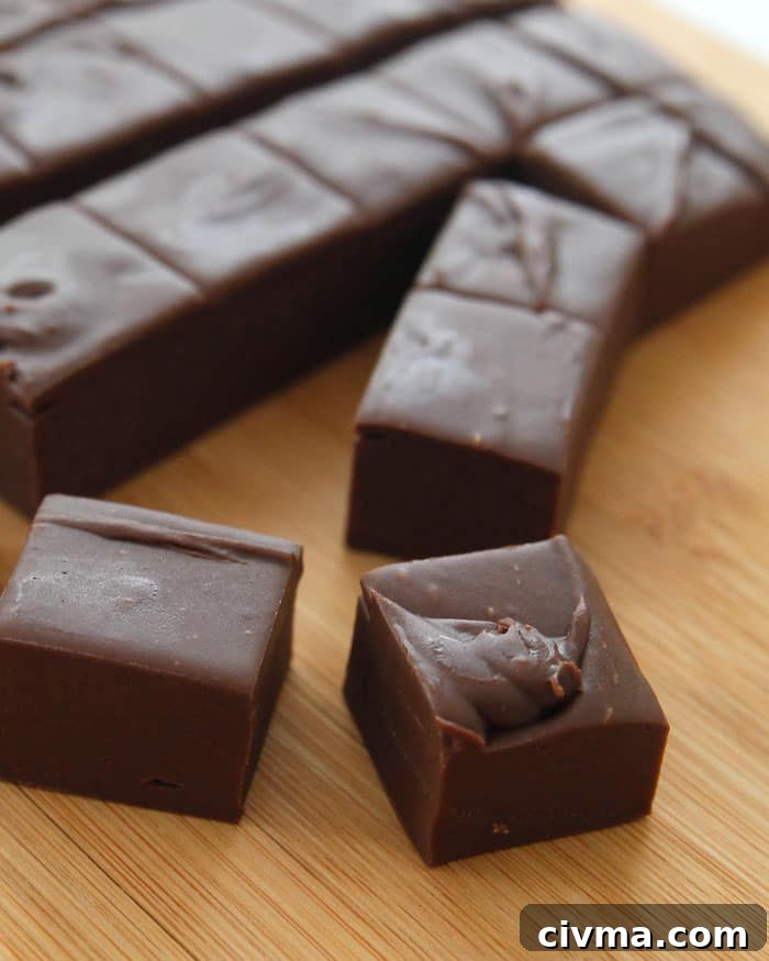 3 minute fudge Three minute fudge cut into squares on a wooden board. 2 squares are separated from the rest in the front of the image.