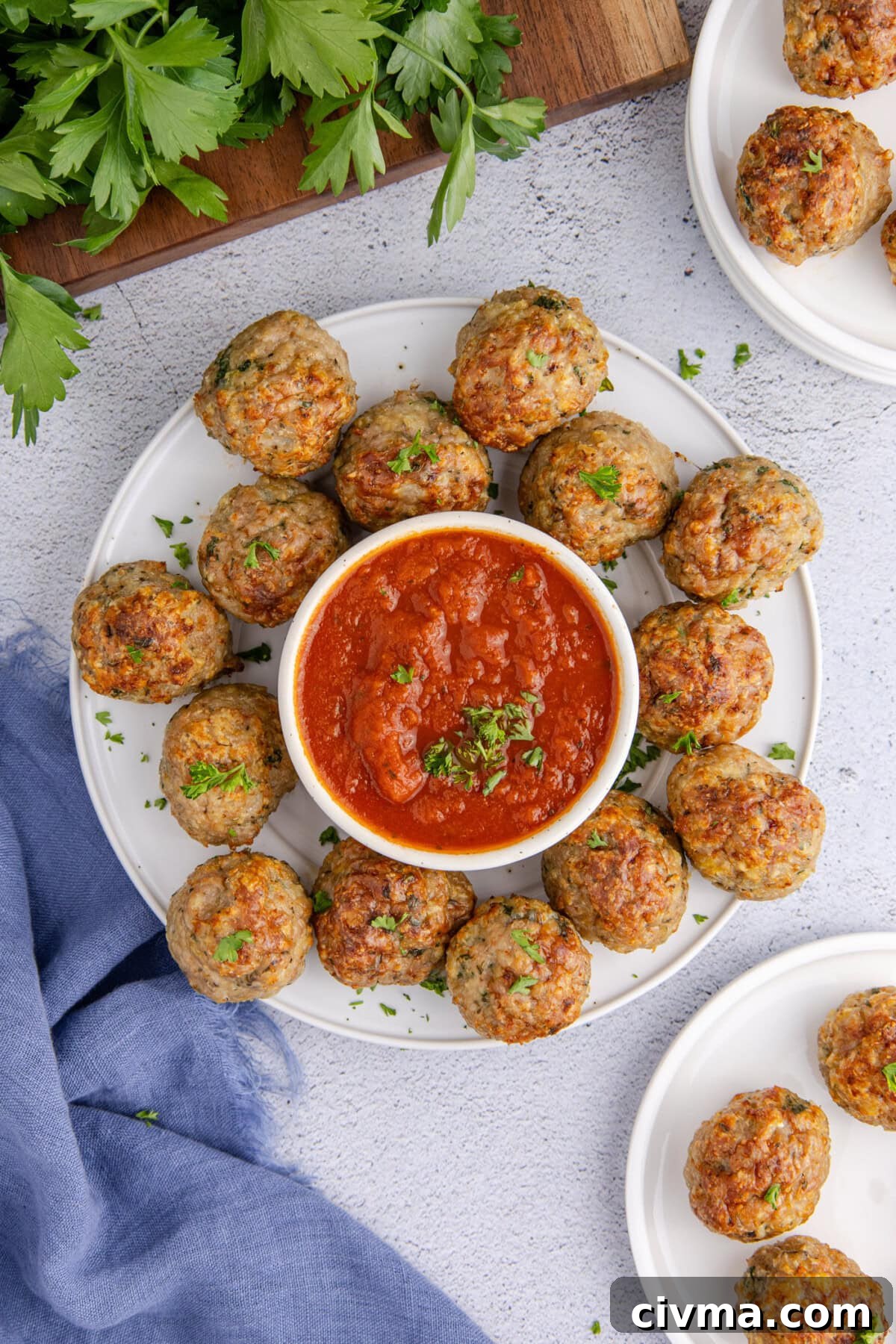 Plate of Chicken Meatballs with a bowl of marinara sauce 