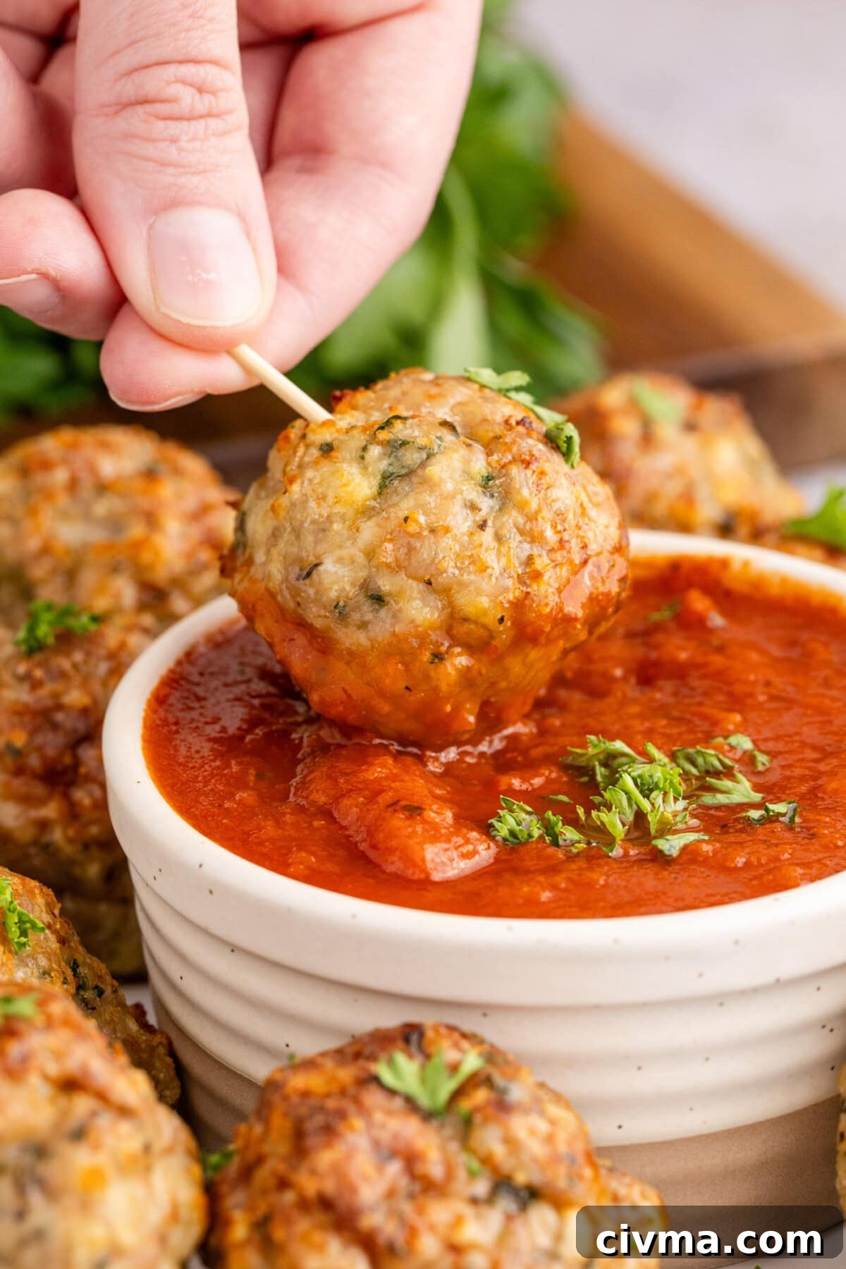 Chicken Meatball being dipped in marinara sauce