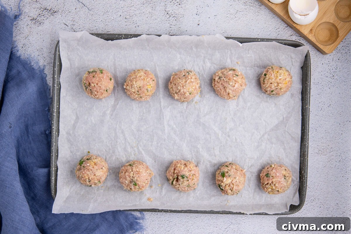 chicken meatballs on a parchment lined baking sheet