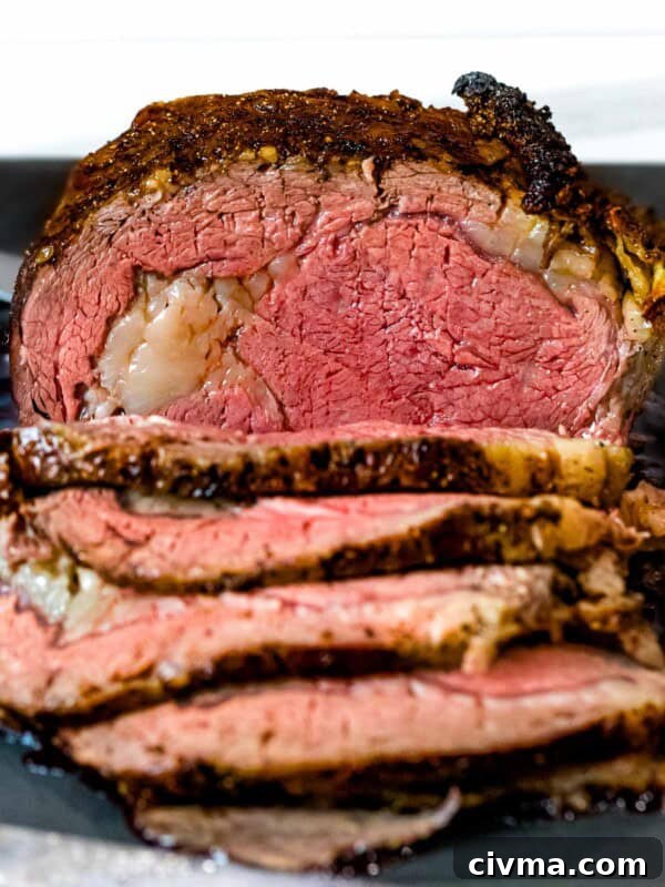 Prime rib roast with brown crust cut into slices on a dark cutting board.
