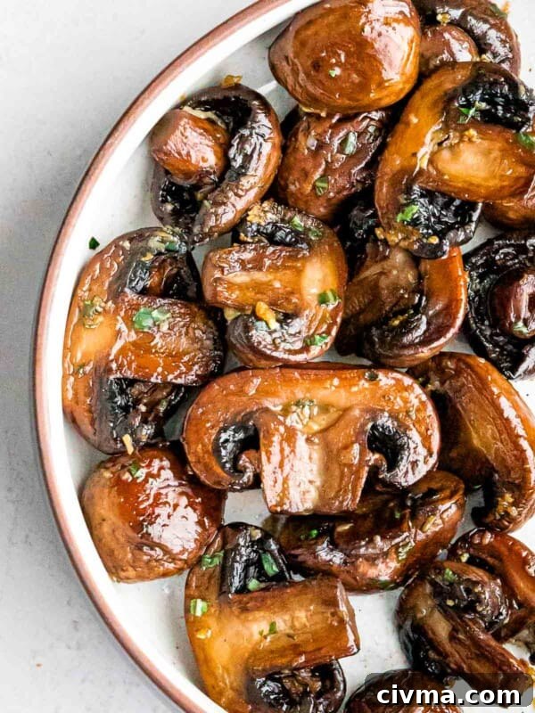 overhead of golden brown sauteed mushrooms with garlic and chopped parsley