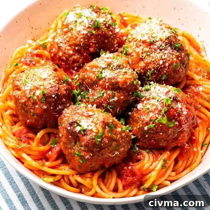 Italian meatballs with parmesan cheese on top of spaghetti.