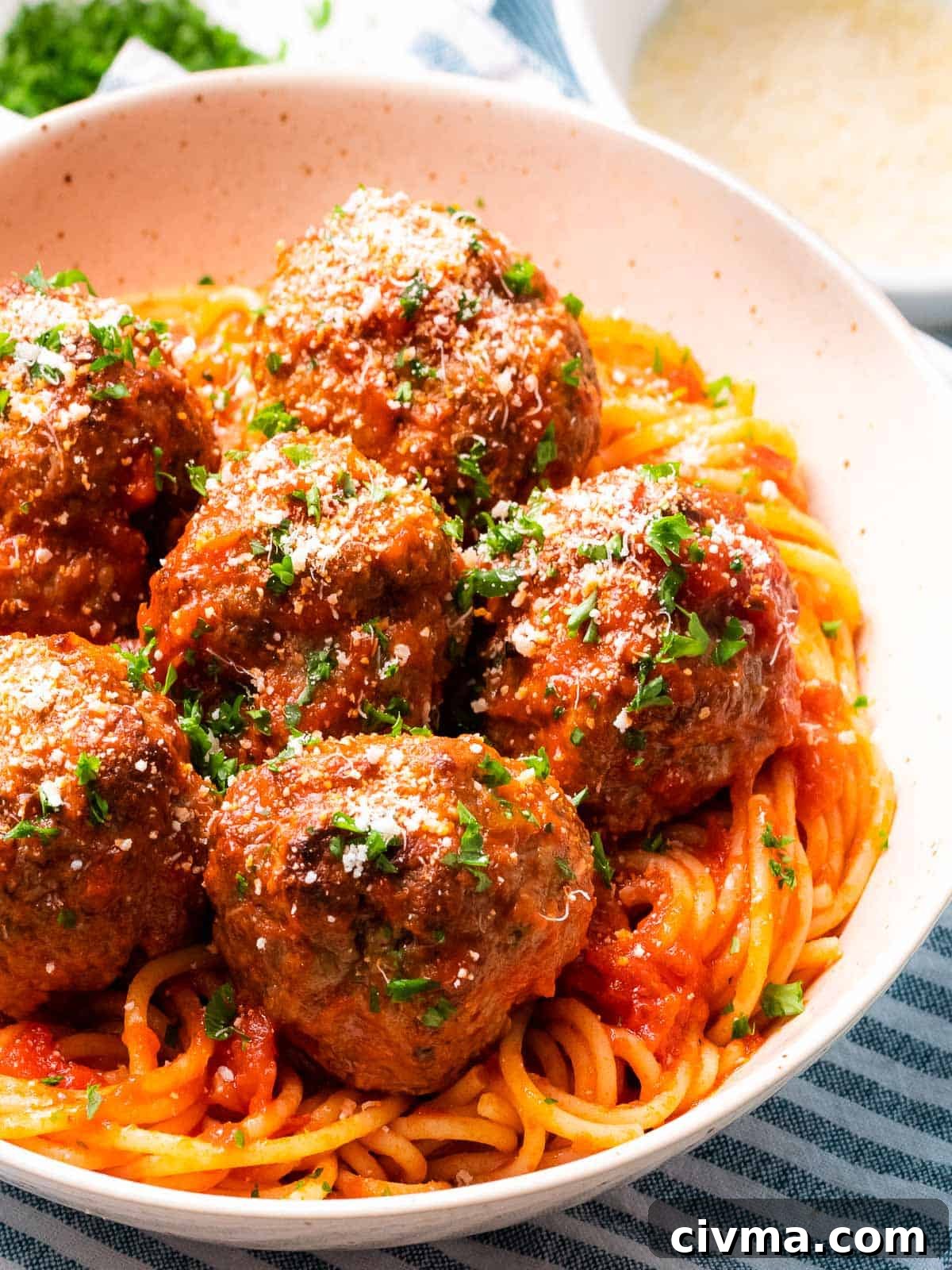 Italian meatballs baked until tender and juicy with a bowl of spaghetti.