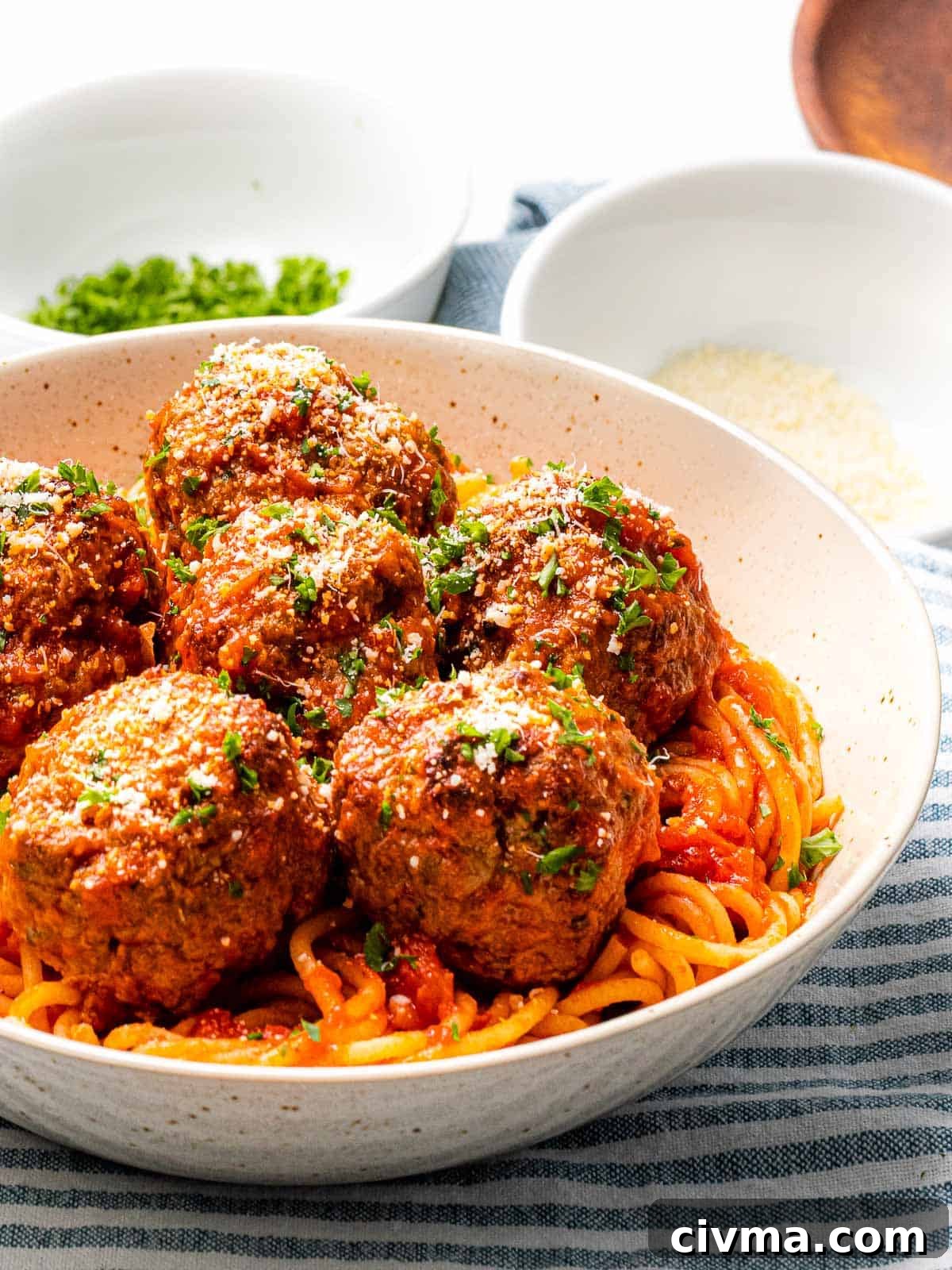 Tender and juicy Italian meatballs with a bowl of pasta.