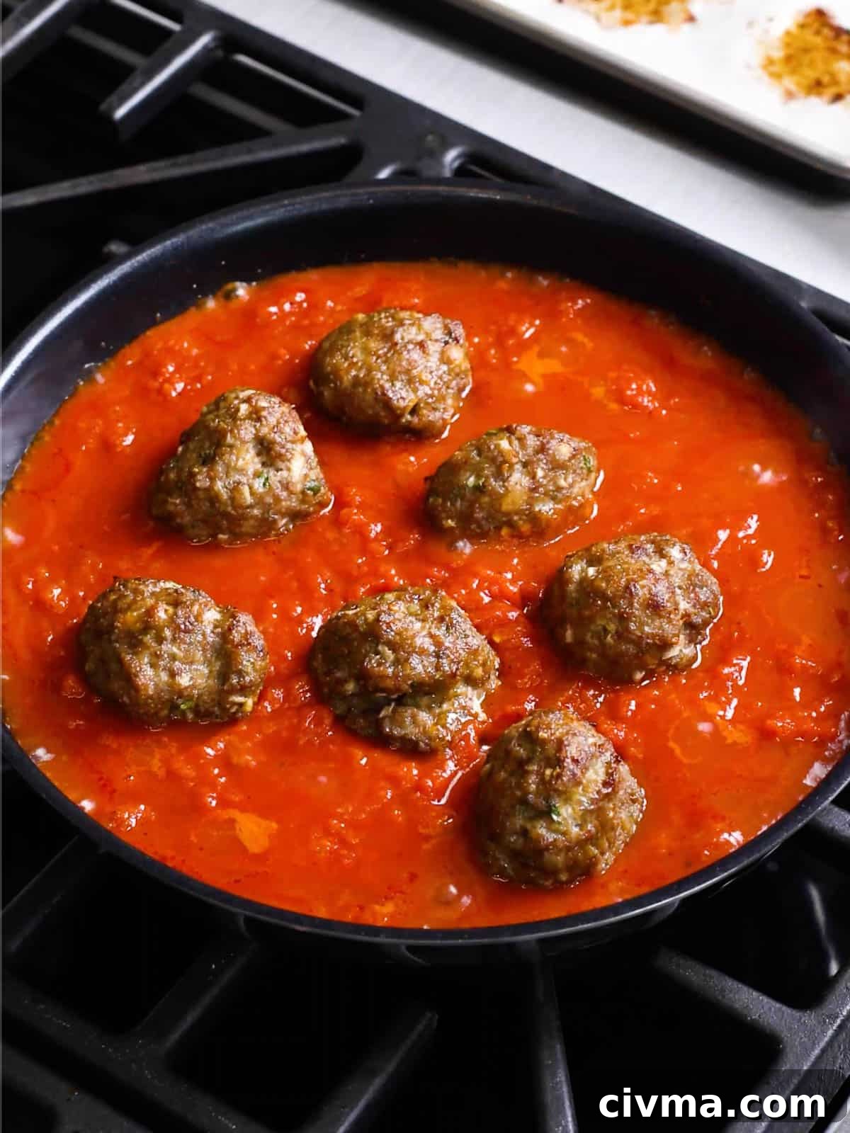 Homemade Italian meatballs simmering in tomato sauce.