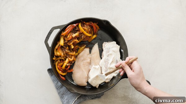 Chicken Fajita Casserole -- easy weeknight recipe with fajita veggies, black beans, sour cream and cheese on chicken breasts & baked in a cast iron skillet.