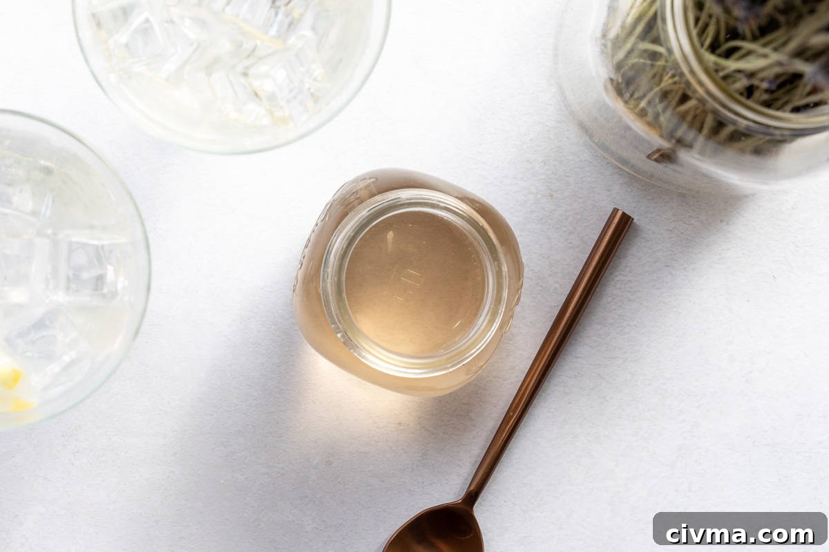 overhead of jar of lavender syrup next to spoon.