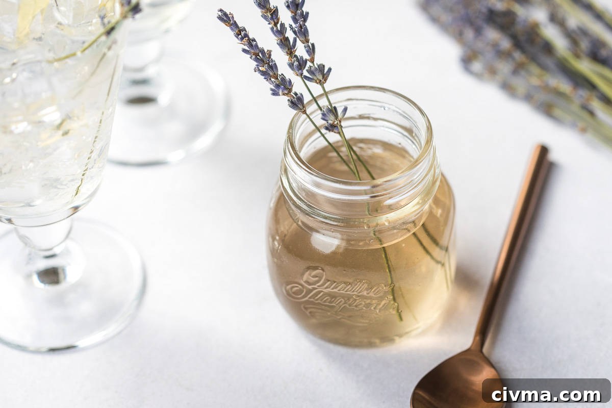 glasses with ice next to jar of lavender syrup with sprigs of lavender.