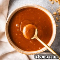 A teaspoon of creamy peanut hoisin sauce scooped from a small bowl.