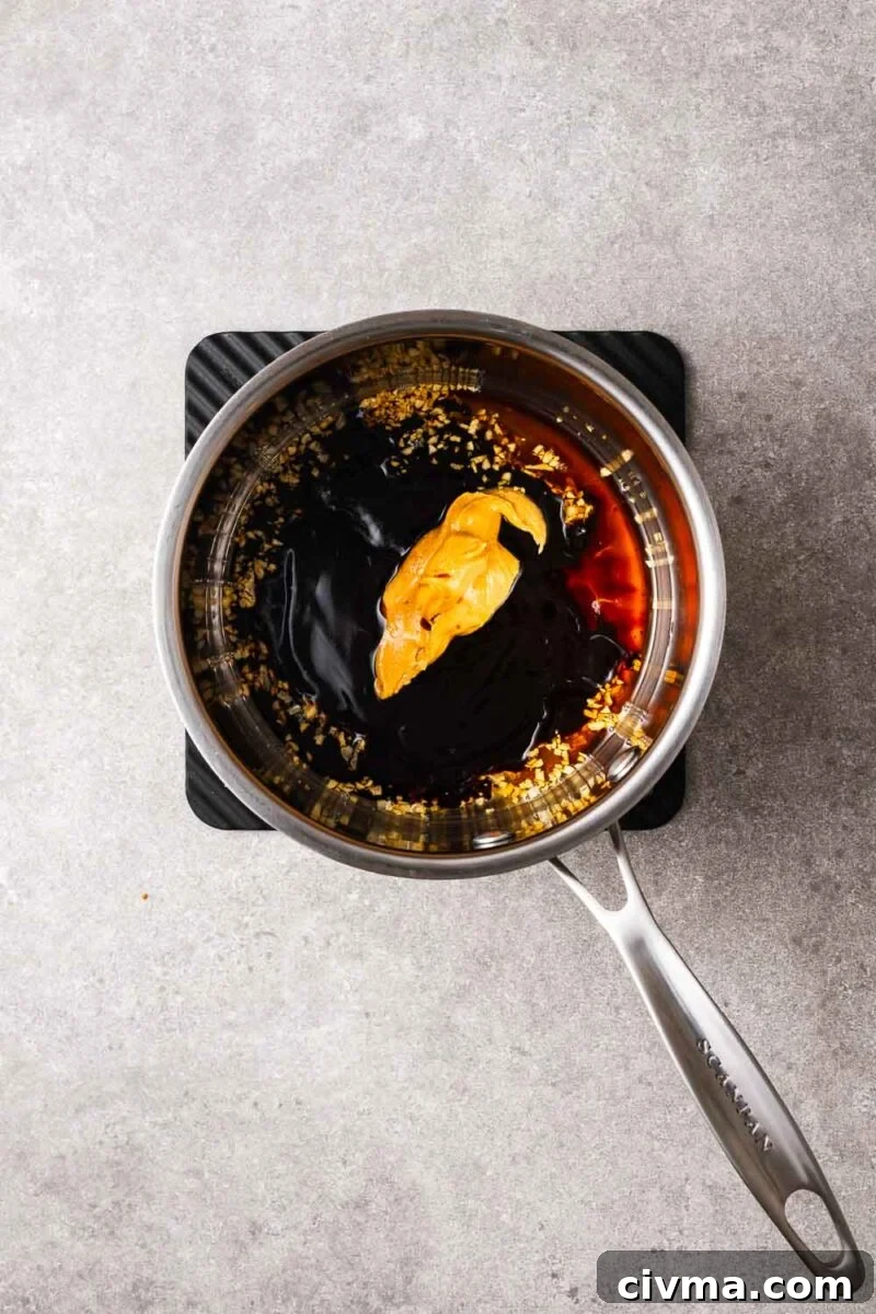 Peanut butter and hoisin dipping sauce ingredients in a saucepan.