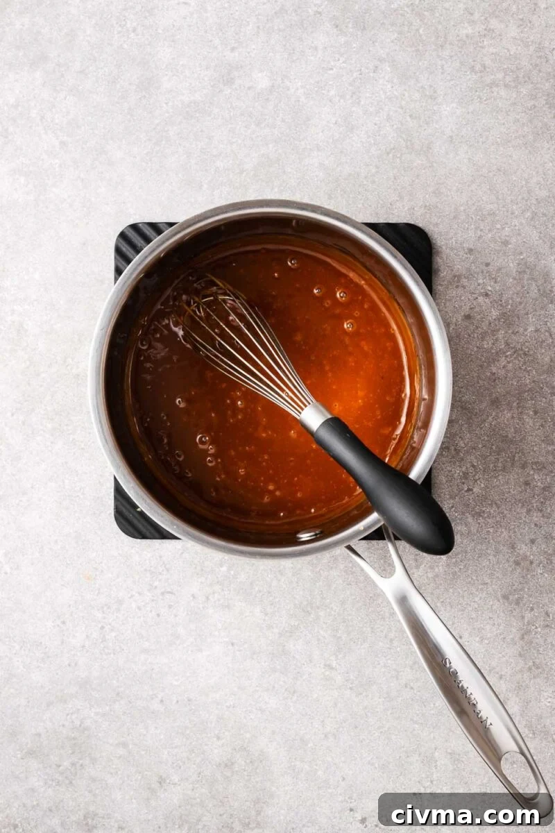 Cooked peanut hoisin sauce in a stainless steel saucepan with a homogenous texture.