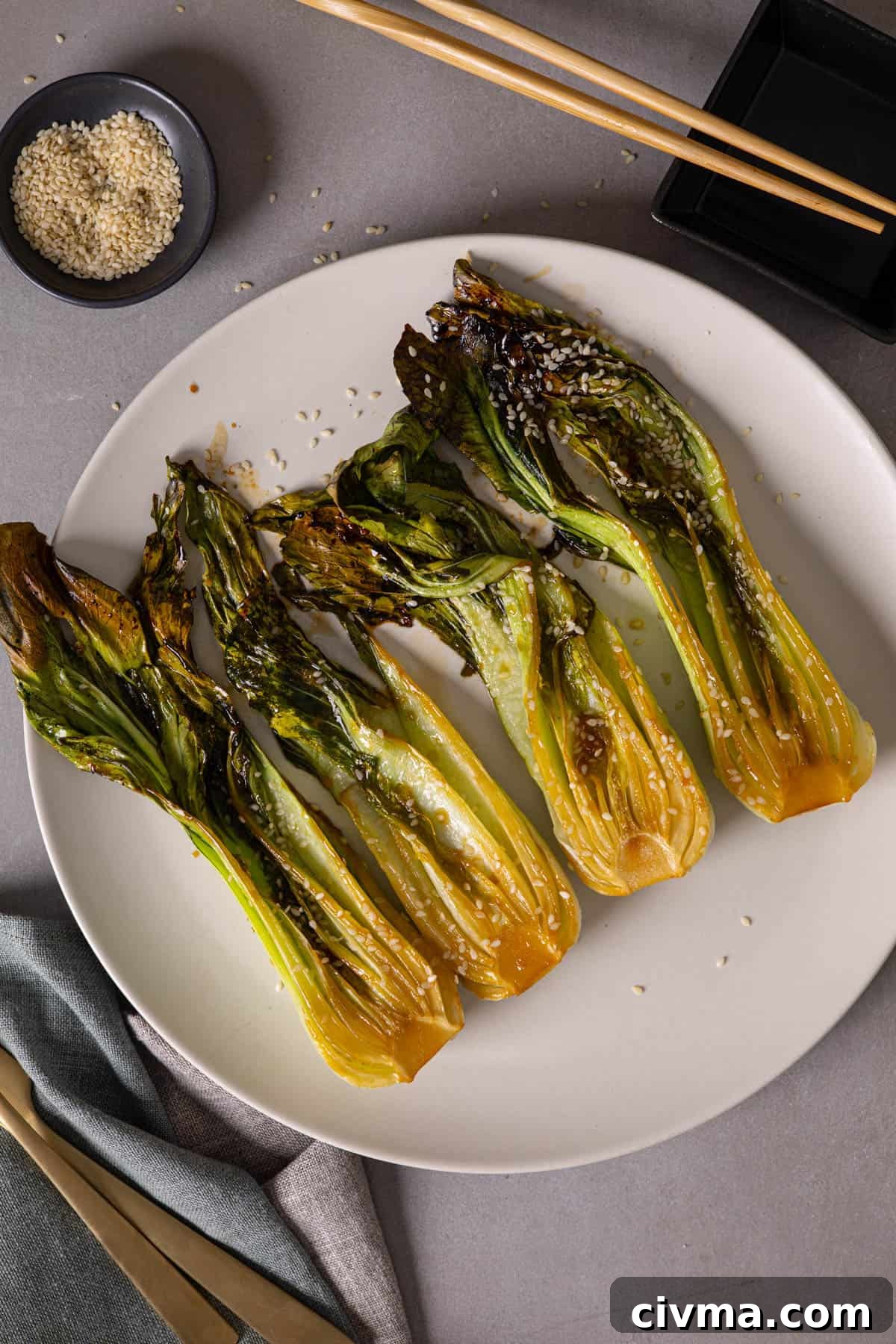 Roasted Bok Choy Recipe with Garlic and Sesame 2 A platter of roasted bok choy lightly browned and garnished with sesame seeds.