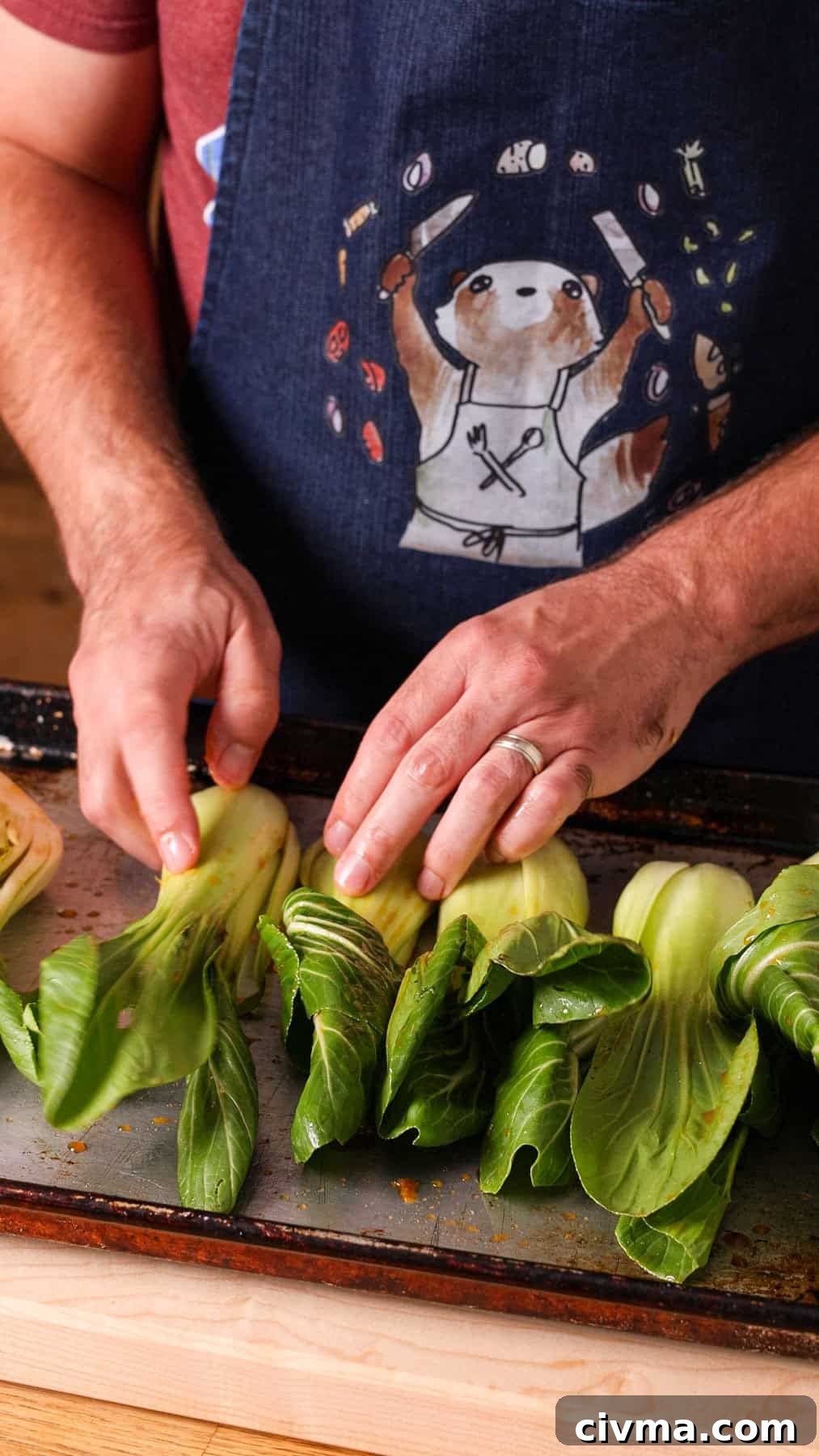 Roasted Bok Choy Recipe with Garlic and Sesame 7 Baby bok choy in a soy ginger sauce getting layer on a baking sheet to roast.
