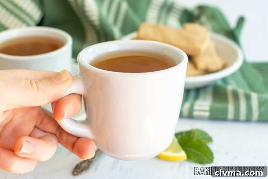 hand holding tea cup with honey citrus mint tea recipe