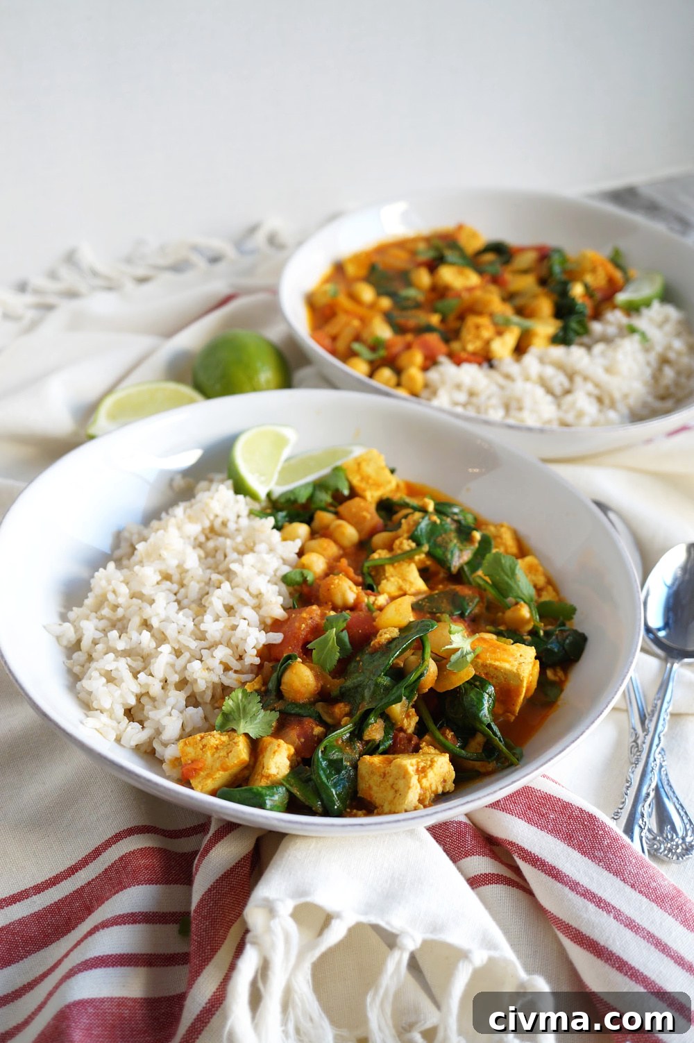 plates of vegan chickpea curry with tofu and spinach