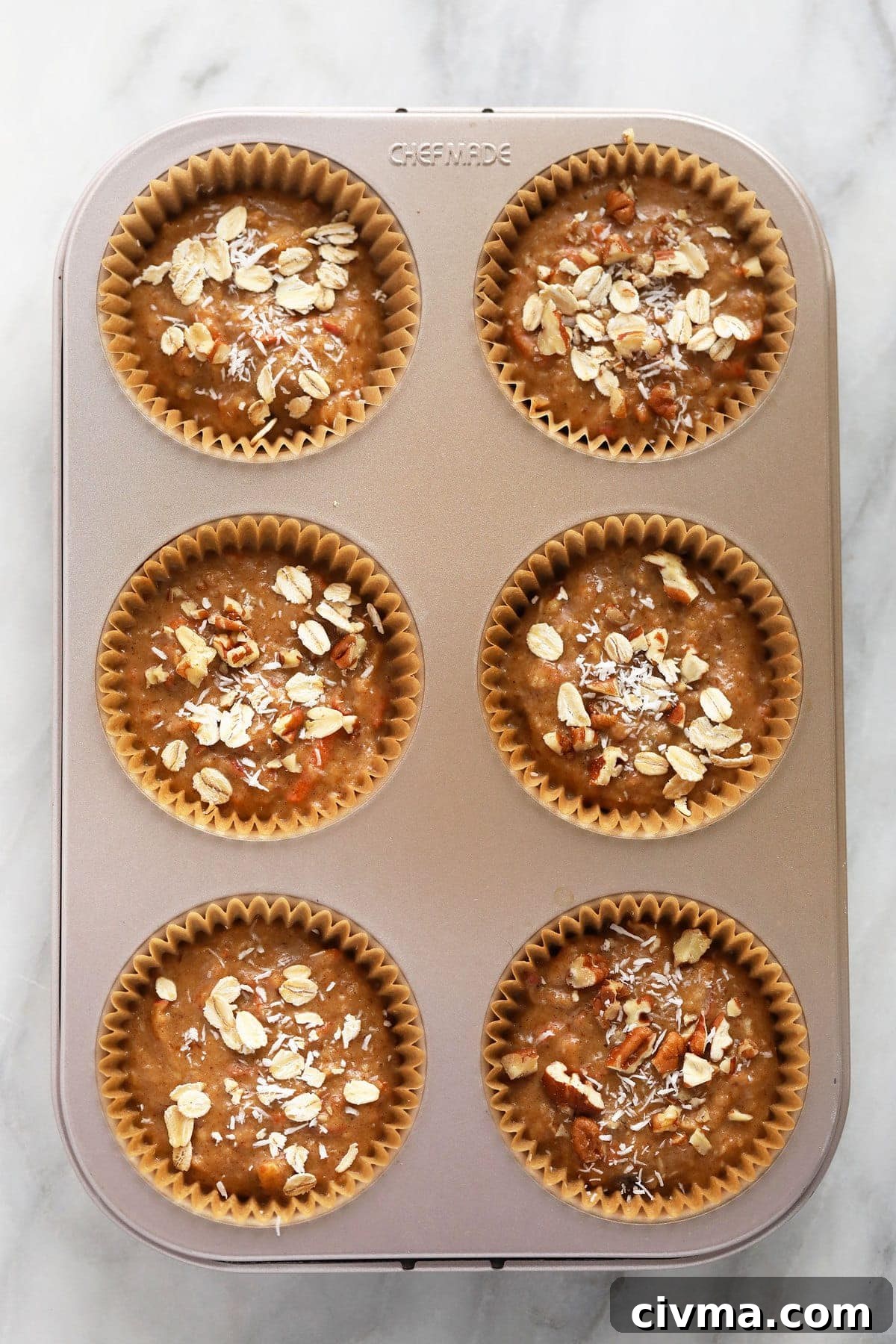 Muffin cups with muffin batter in them. 