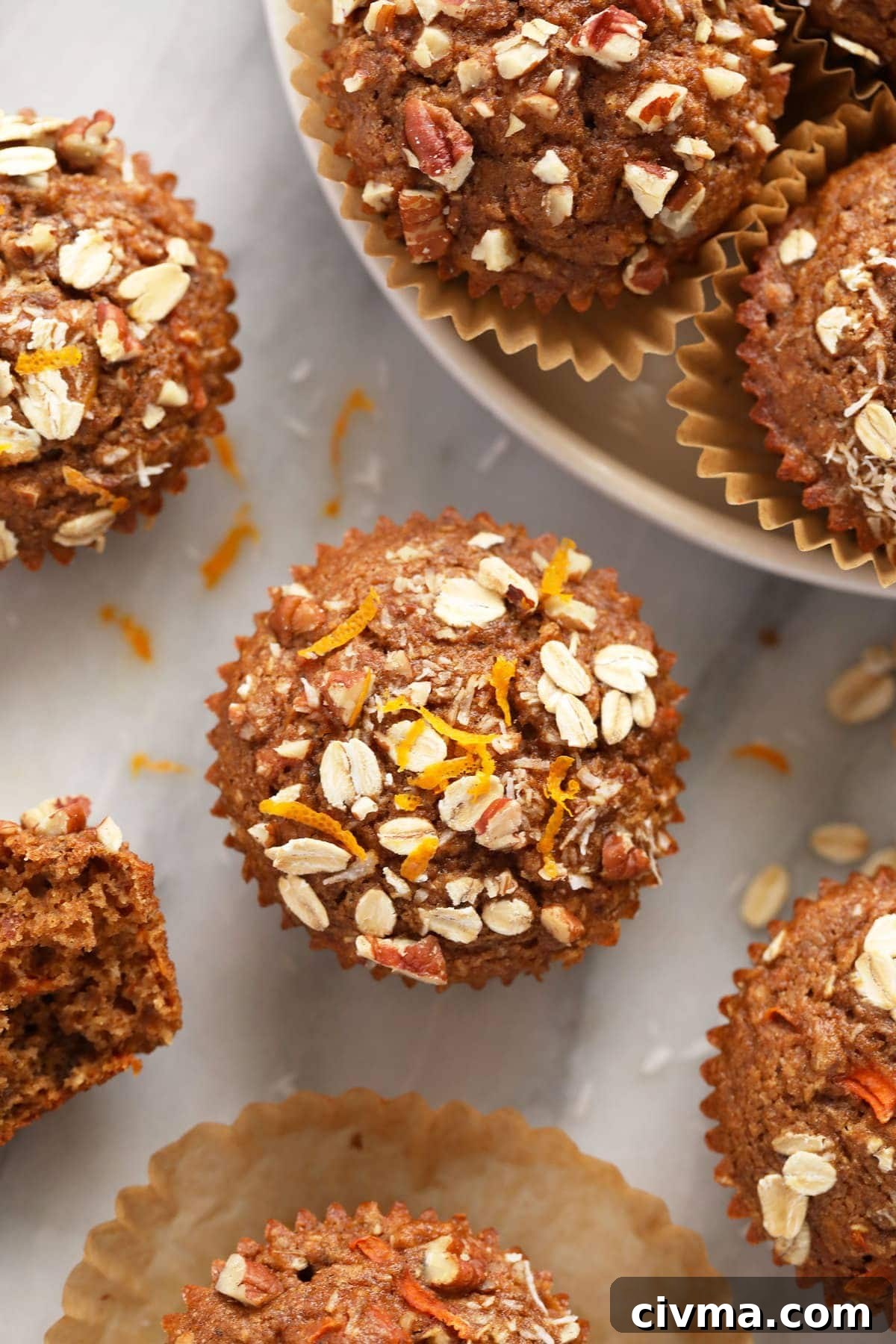 A morning glory muffin with fresh orange zest on top of the muffin. 