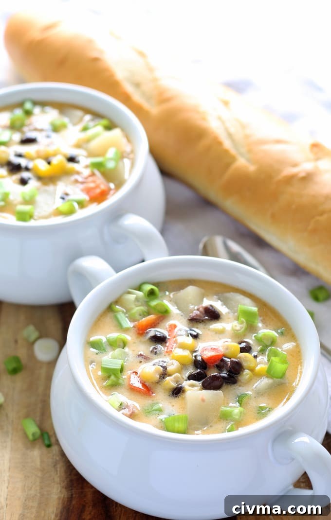 two bowls of black bean corn chowder and a loaf of bread