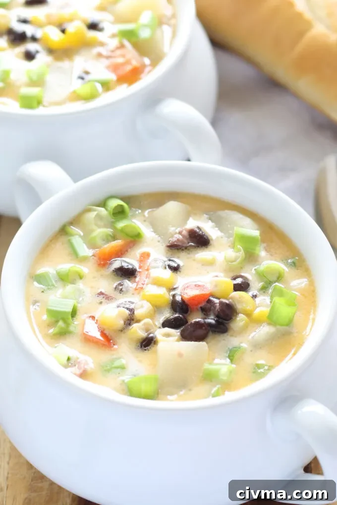 two white soup bowls of chowder with fresh green onions as garnish