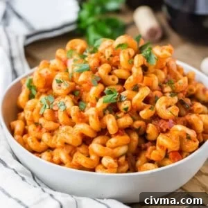 Pasta with pancetta and tomato sauce in white bowl.