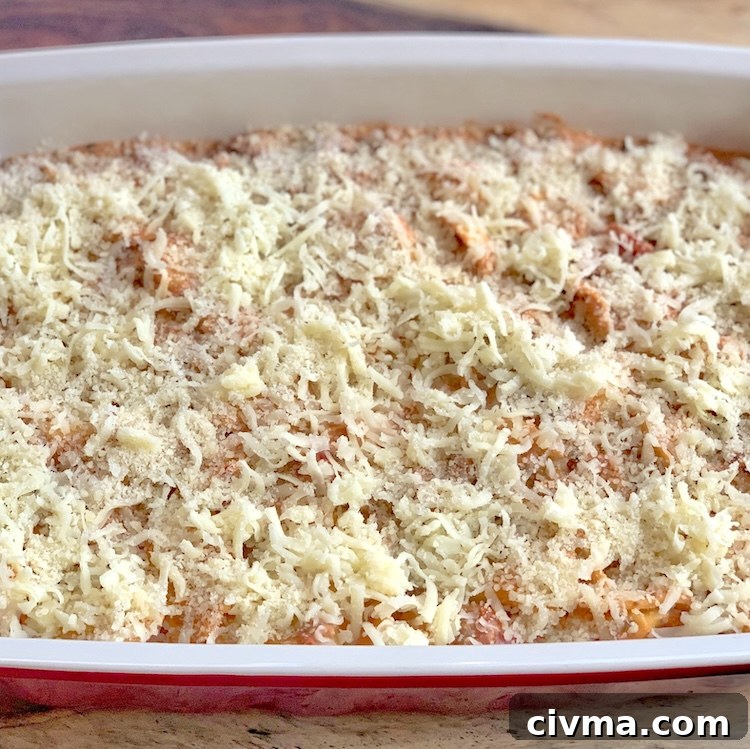 Cheesy tortellini casserole topped with mozzarella and parmesan before baking.