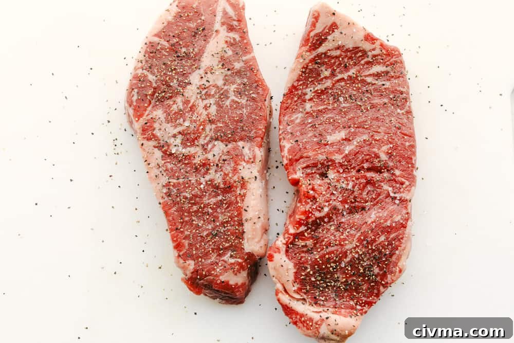 Two steaks seasoned with salt and pepper. 