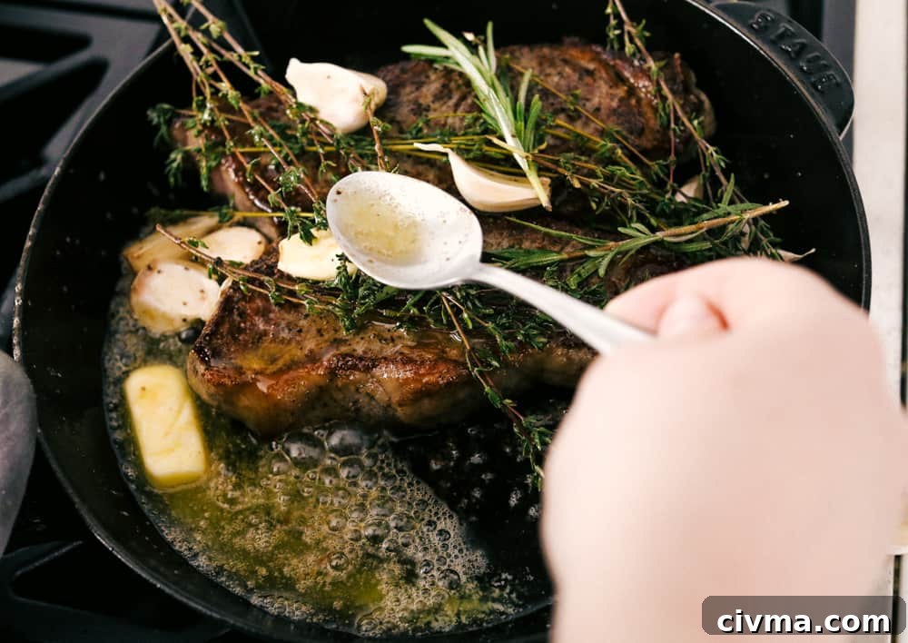 Steak cooking in a black pan with butter and garlic. 