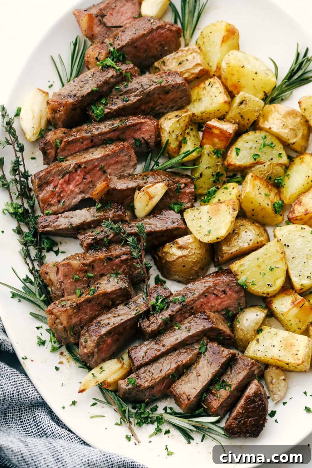 Cut up steak and potatoes on a white plate. 