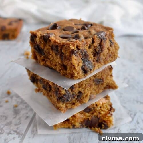 3 chocolate chip pumpkin blondies stack on top of each other.