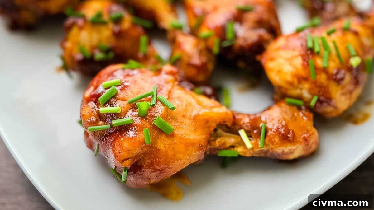 Juicy BBQ chicken legs on a serving tray, garnished with chives.