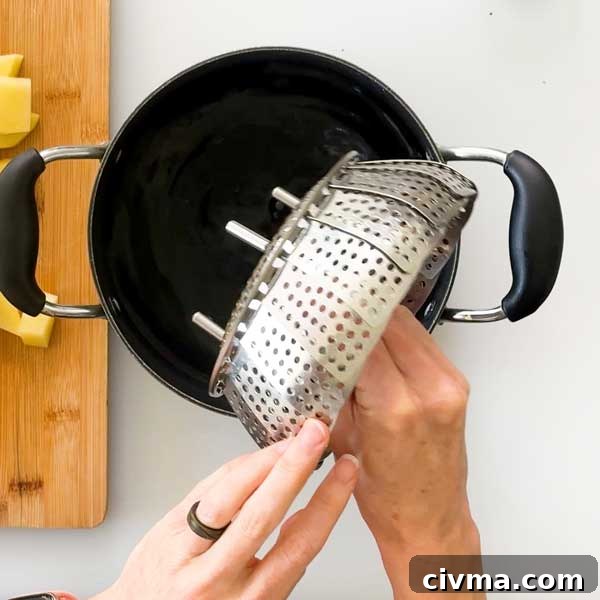 Creamy Garlic Cottage Cheese Mashed Potatoes 6 Placing a steamer basket in a saucepan filled with water.
