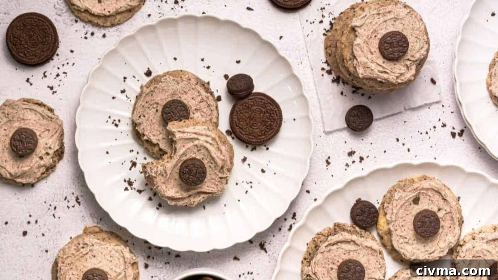 Copycat Crumbl Cookies and Cream Milkshake Cookies arranged on white plates and a light surface with cookie crumbs scattered around.