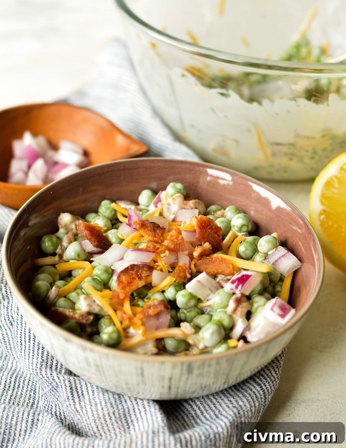 a bowl of pea salad with bacon and cheese