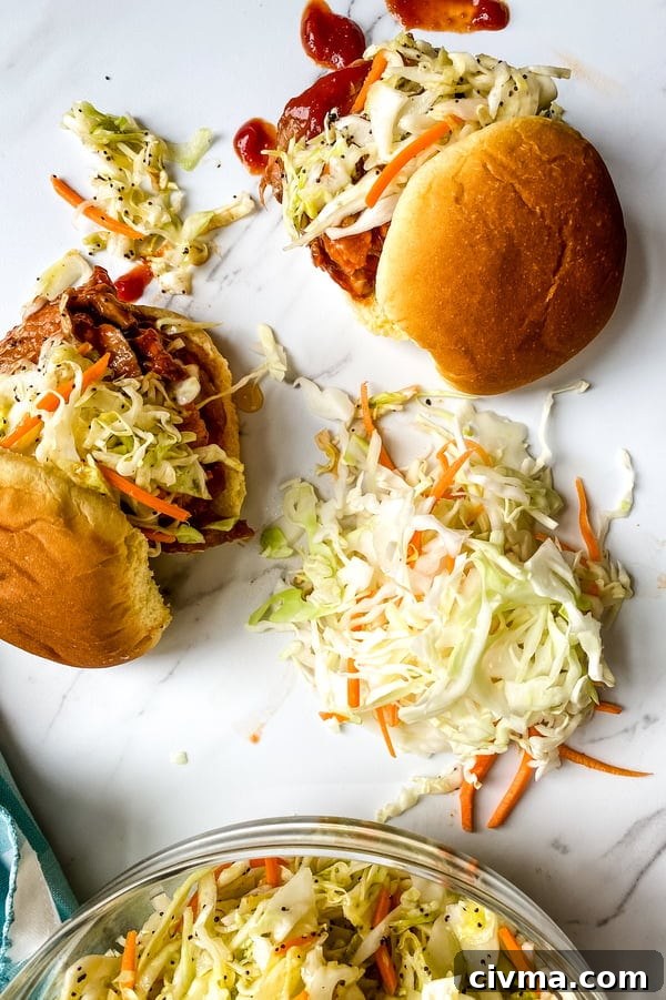 Cole slaw and 2 barbecue pork tenderloin sliders.