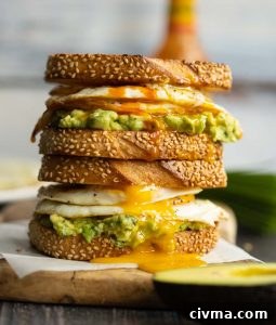 two sandwiches stacked on each other with yolk dripping down