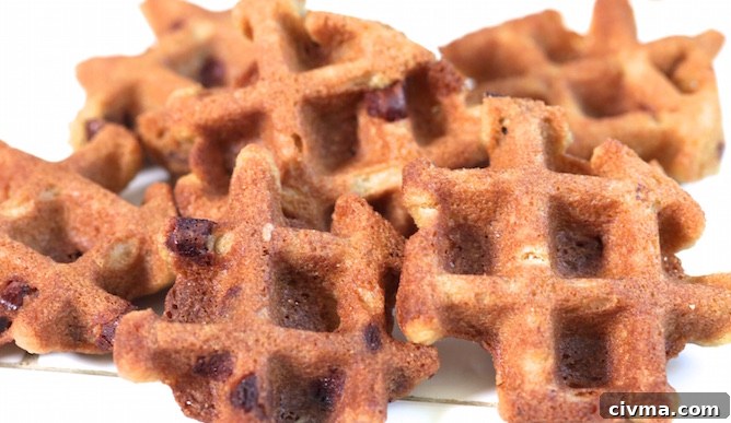 A pile of chocolate chip cookies cooked in a waffle maker on a white background