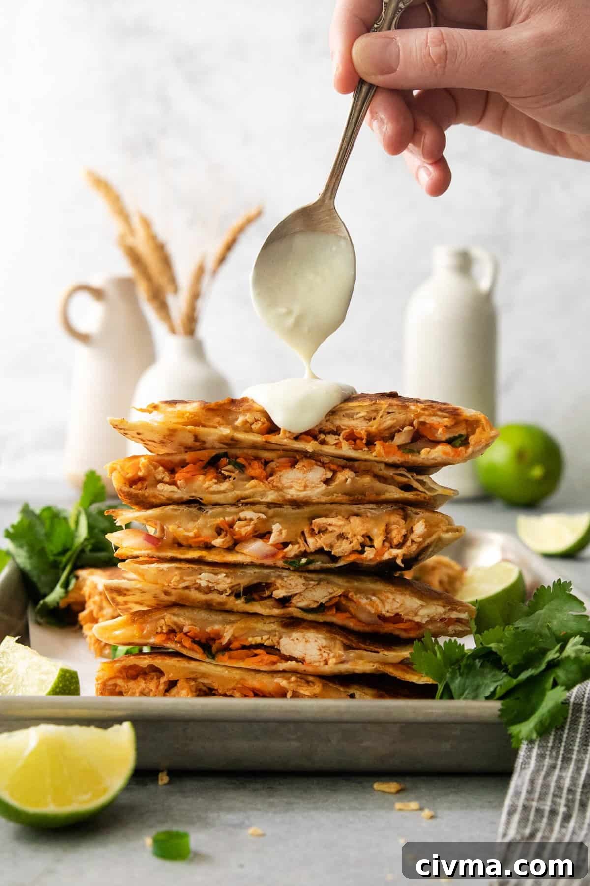 Buffalo Chicken Quesadilla Recipe 2 A stack of chicken quesadillas on a plate with a scoop of guacamole.
