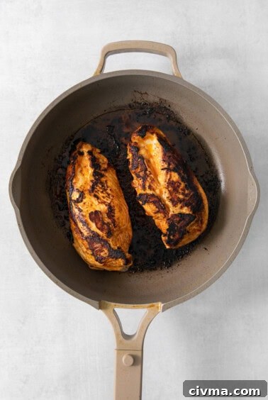 Buffalo Chicken Quesadilla Recipe 10 A frying pan with two chicken breasts in it.