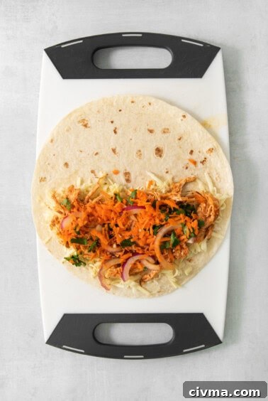 Buffalo Chicken Quesadilla Recipe 12 A taco on a cutting board with carrots and onions.