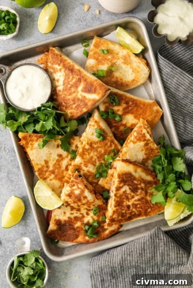 Buffalo Chicken Quesadilla Recipe 14 Quesadillas on a baking sheet with lime wedges.