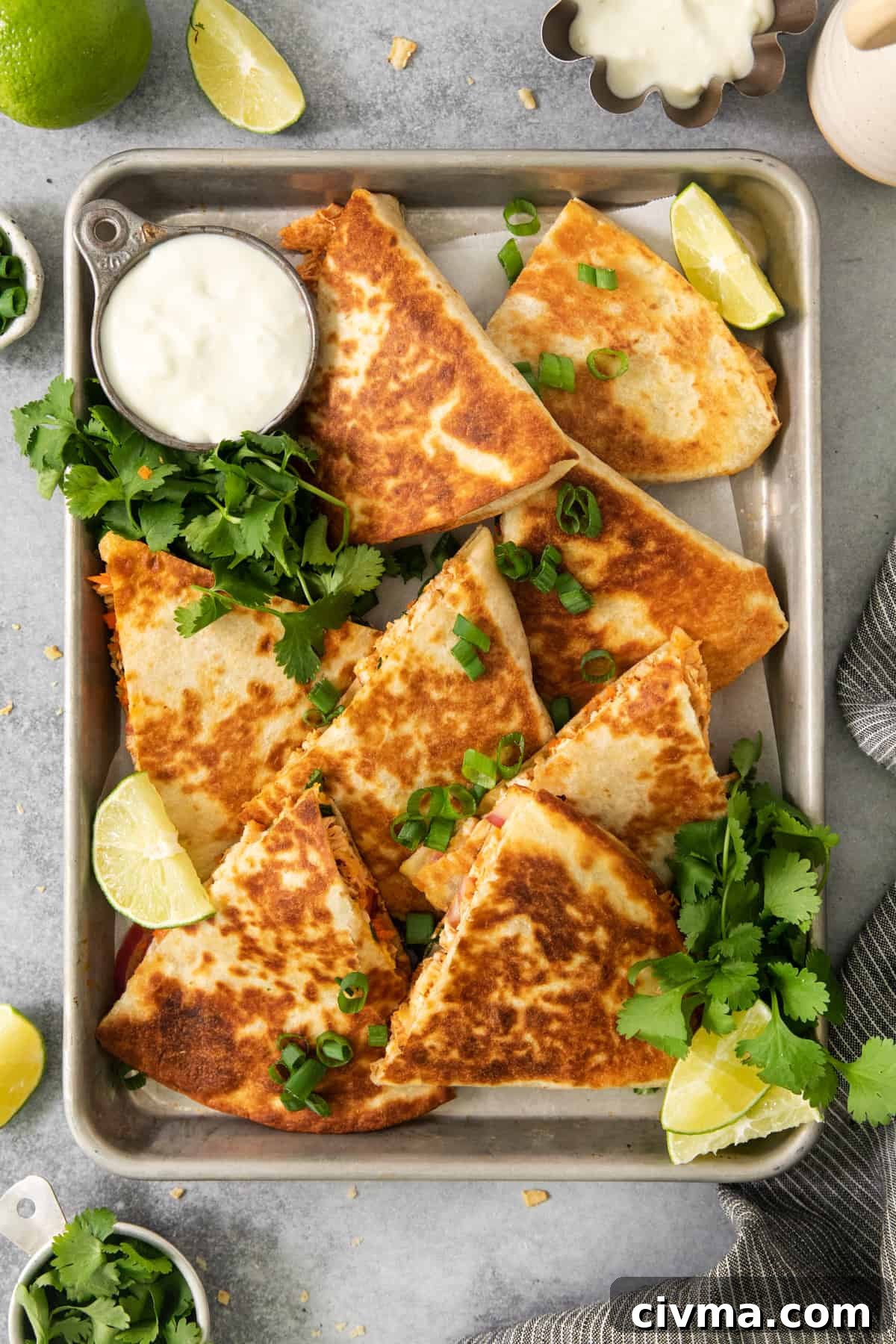 Buffalo Chicken Quesadilla Recipe 4 Chicken quesadillas on a tray with lime wedges.
