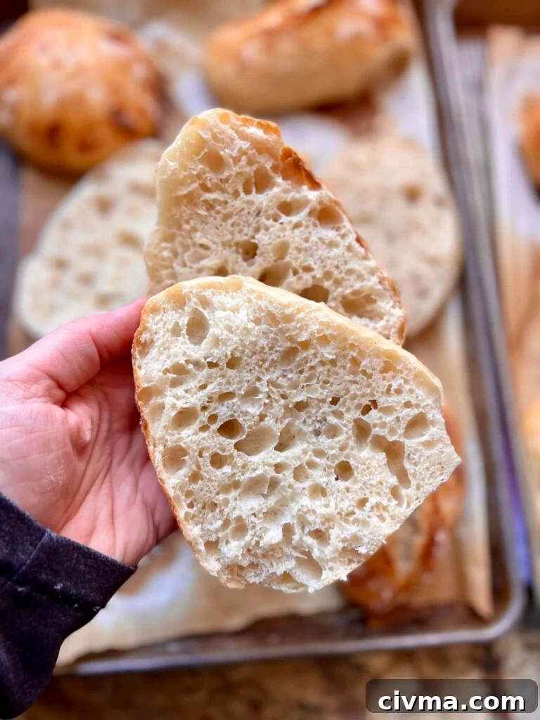 How to Reduce Sourness in Sourdough Bread 2 A sourdough loaf is sliced in half and held out to the camera.