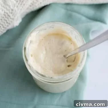 How to Reduce Sourness in Sourdough Bread 8 Jar of active sourdough starter with a spoon showing a smooth, bubbly texture.