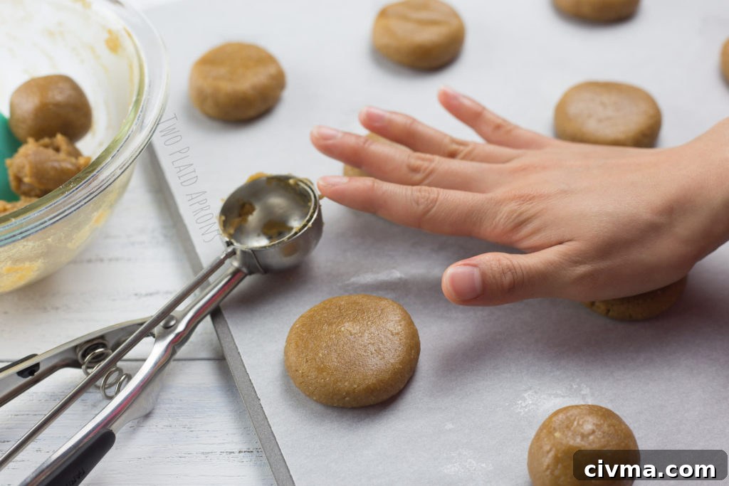 Gluten-Free Chewy Peanut Butter Cookies Recipe 4 Lightly flattening the gluten free peanut butter cookie doughs with palm.