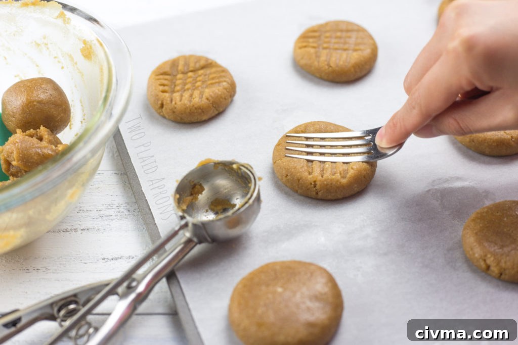Gluten-Free Chewy Peanut Butter Cookies Recipe 5 Making criss-cross indentions with a fork on gluten free peanut butter cookies.