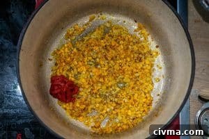 Adding the tomato paste to the pot