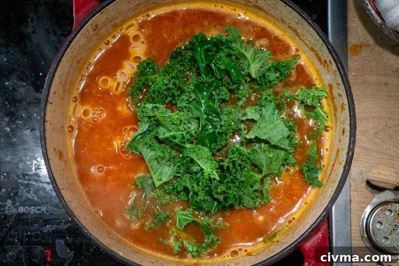 Adding the pasta and kale to the pot