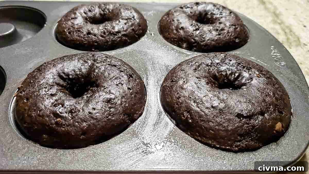 4 baked donuts in a donut pan.